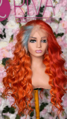 a red and blue wig is on a mannequin in front of flowers