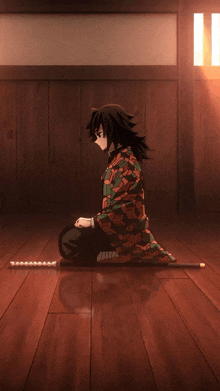 a man is kneeling down on the floor with a sword in his hand