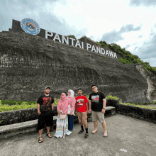 a group of people are posing in front of a sign that says pantai pandawa