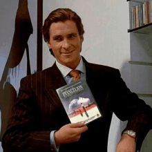 a man in a suit and tie is holding a dvd of evangelion