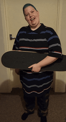 a man in a striped shirt is holding a large skateboard