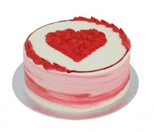 a cake with a red heart on top of it on a plate .