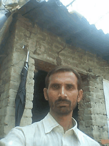 a man takes a selfie in front of a brick wall