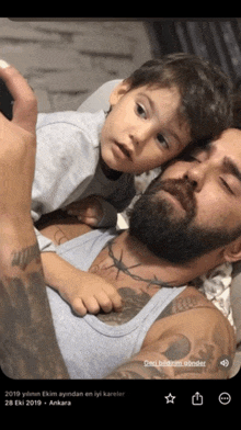 a man with a beard is laying down with a child