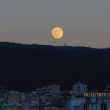 a full moon is visible over a city on december 26th