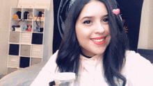 a woman wearing headphones is smiling in front of a shelf that says " i love you " on it