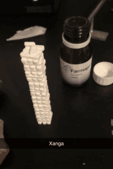 a bottle of farmape sits on a table next to a stack of pills