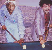 two men are playing pool and one is wearing a bandana around his head