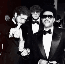 three men in tuxedos and sunglasses are posing for a photo