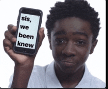 a young boy holds up a cell phone that says " sis we been knew "