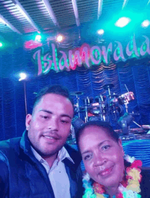 a man and a woman pose for a picture in front of a sign that says islamorada