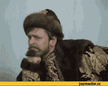 a man with a beard wearing a fur coat and hat with joyreactor.cc written below him