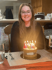 a woman sitting in front of a birthday cake with candles that say happy 15th