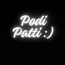 a neon sign that says " podi patti :) " on a black background