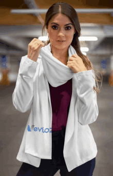 a woman is wearing a white jacket with the word nevioz on it