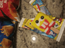 a spongebob popsicle sits on a counter next to a bag of chili nachos