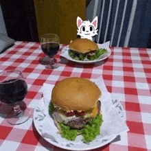 two hamburgers and a glass of wine on a checkered tablecloth .