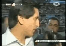 a man is talking into a microphone with the words el tecnico mas hincha behind him