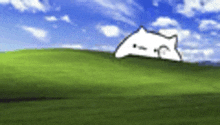 a white cat is laying on top of a green hill .