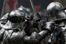 two knights in armor are fighting with swords and one has a blue shield with the numbers 00 on it