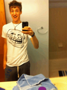 a young man taking a selfie in front of a mirror