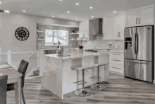 a kitchen with a stainless steel refrigerator and a large island