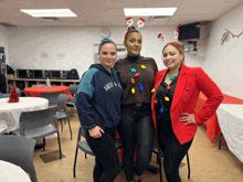 three women posing for a picture with one wearing a sweatshirt that says america