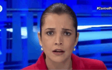 a woman is making a funny face while standing in front of a blue screen .