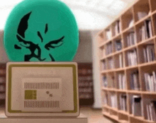 a green ball with a face on it is sitting on a box in a library .