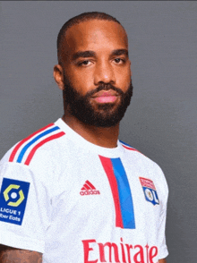 a man with a beard is wearing a white adidas shirt