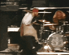 a man in a red bandana is playing drums in front of a drum set with the words psychokiller above him