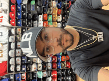 a man wearing a hat that says mlb is standing in front of a display of hats