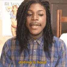 a man with dreadlocks and a plaid shirt is saying dating is hard