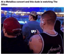 a man in a metallica shirt is watching a metallica concert