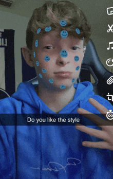 a boy in a blue hoodie has smiley faces painted on his face