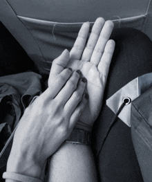 a black and white photo of a person holding another person 's hands