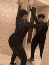 a woman is dancing in front of a mirror .