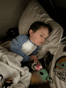 a child is sleeping in a bed with a shirt that says " precis car " on it