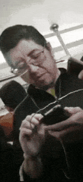 a man wearing glasses is looking at his cellphone