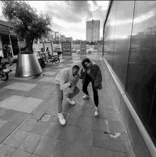 a man and a woman are posing for a picture on a sidewalk