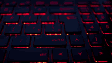 a close up of a keyboard with red lights on the shift and ctrl keys