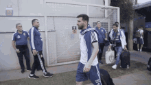 a group of soccer players are walking in front of a building that says ' argentina ' on the wall