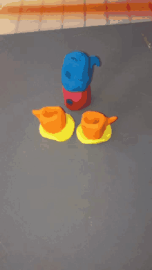 three cups and a pitcher made out of play dough on a table