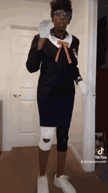 a woman with a knee brace is standing in a hallway with a tiktok logo on the bottom