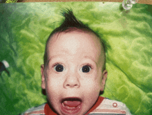 a baby with a mohawk on his head looks surprised