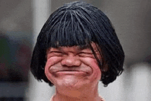 a man wearing a wig and making a funny face .