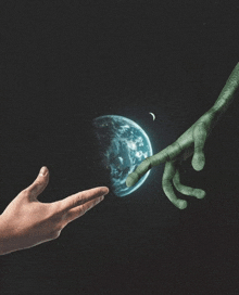 a person 's hand is reaching out towards a planet