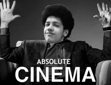 a black and white photo of a man with his hands in the air and the words absolute cinema above him