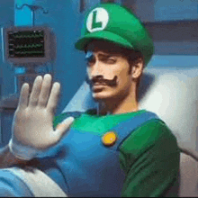 a man in a hospital bed dressed as luigi from super mario is waving his hand .