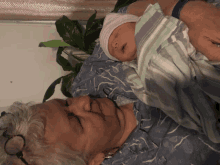 an older woman is holding a newborn baby in her arms